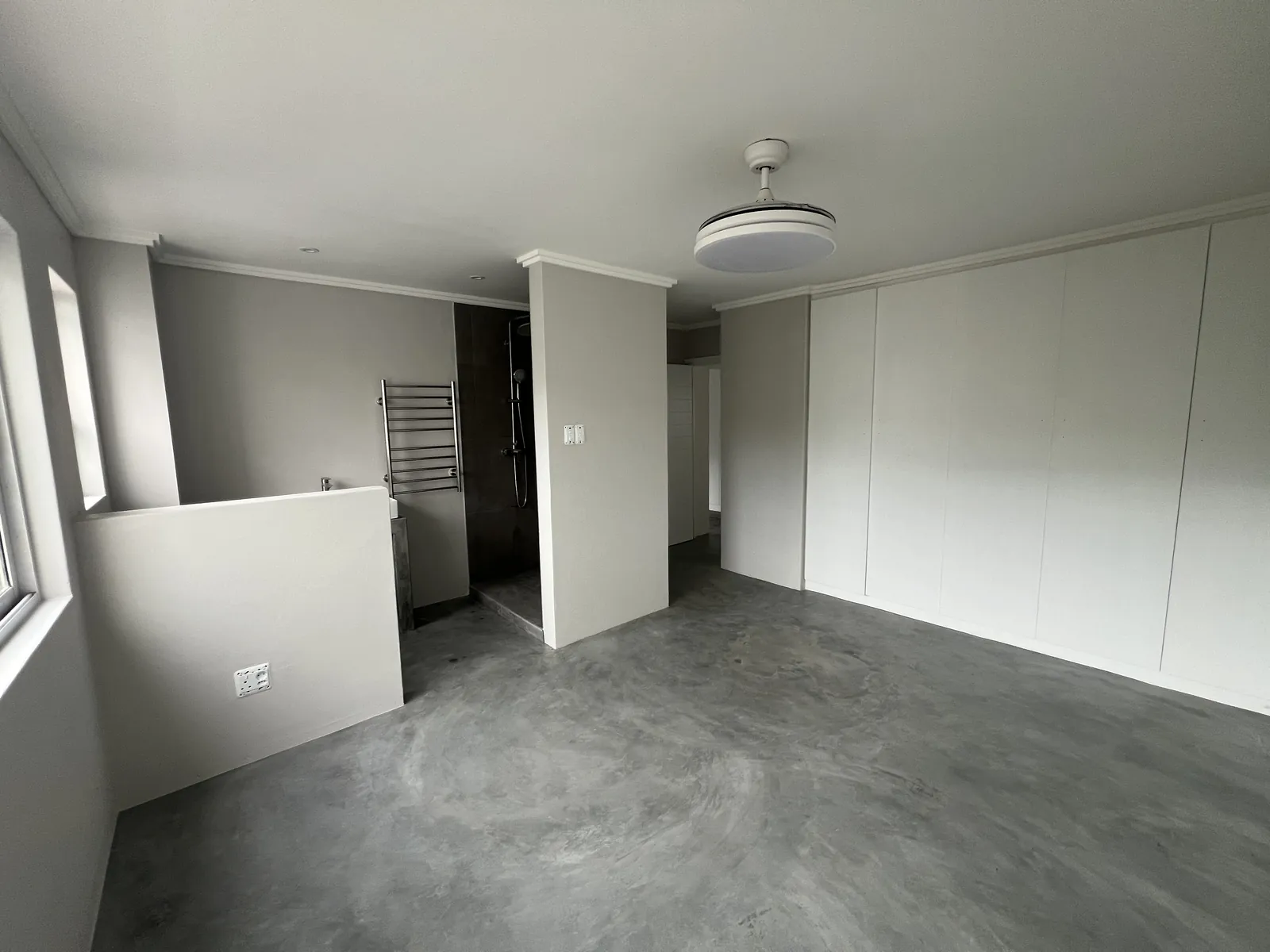 Enlarged main bedroom with open en-suite shower, heated towel rail and built-in cupboards