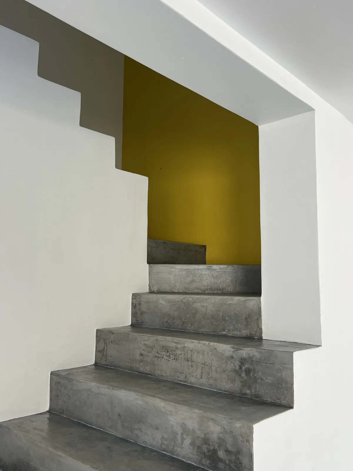 Microcement staircase with a yellow feature wall