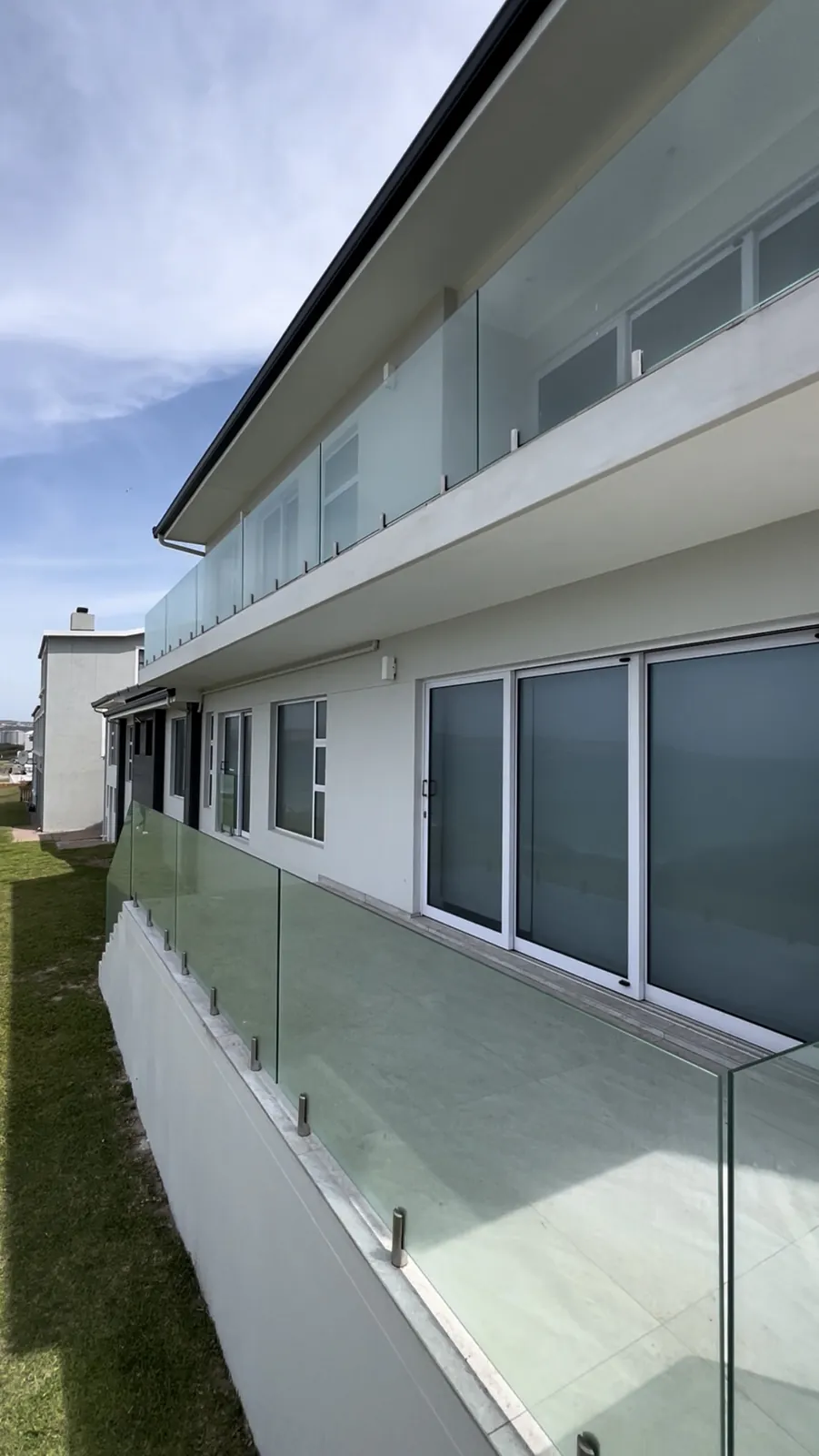 Frameless glass balustrades on the upper balcony and lower terrace
