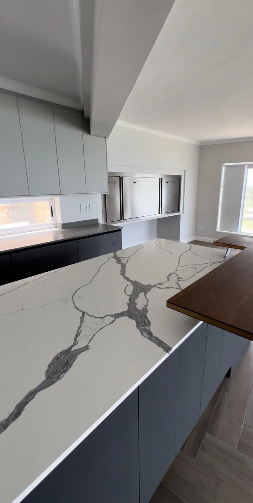 Quartz island with timber breakfast bar and built-in braai