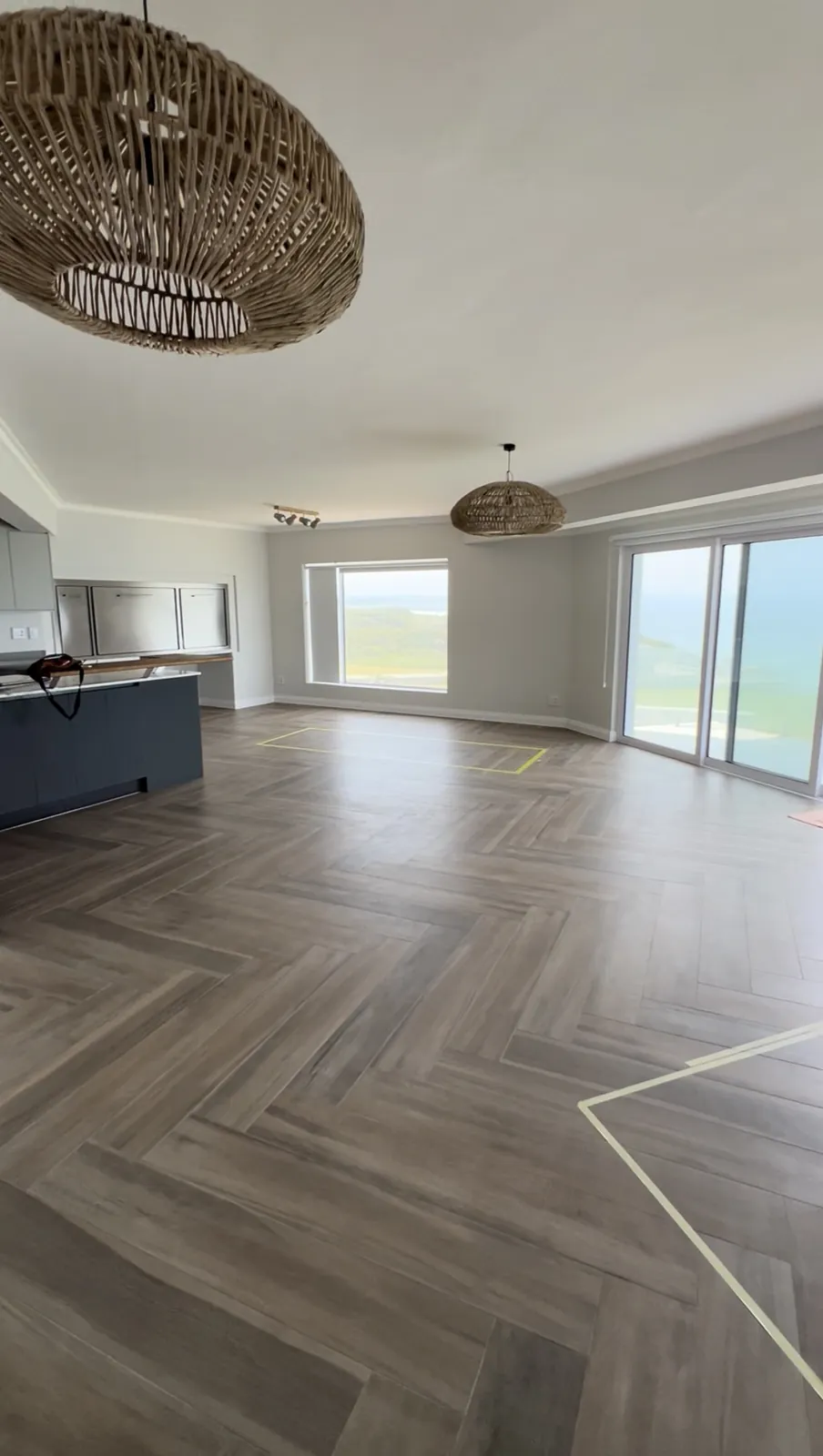 Open-plan living area with herringbone tiles and sea views