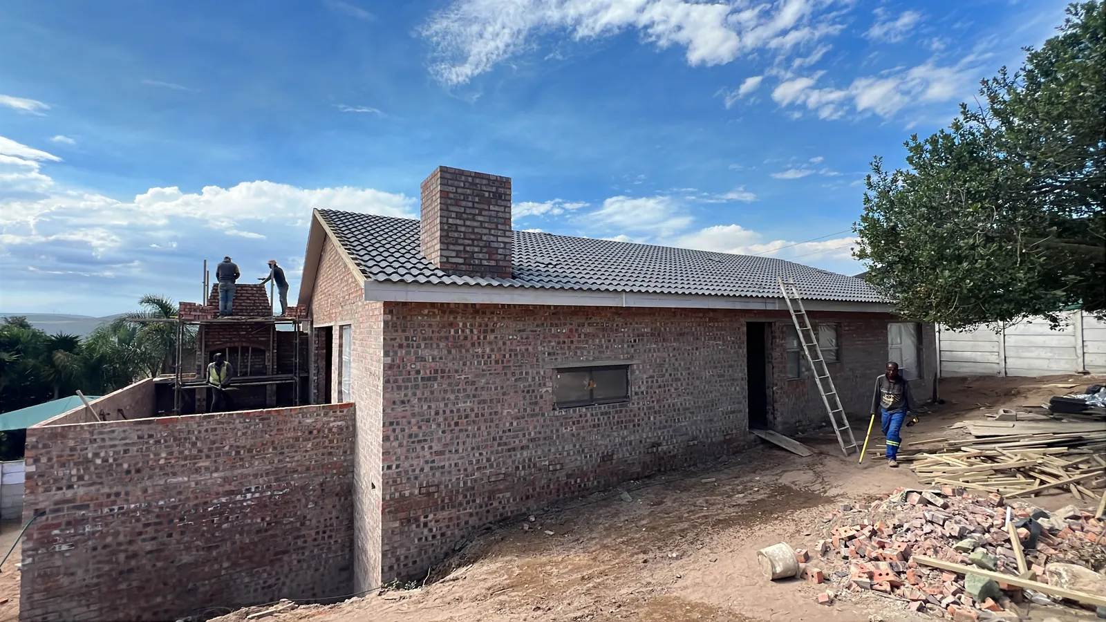 Roof tiled and chimney up while the team builds the balcony braai