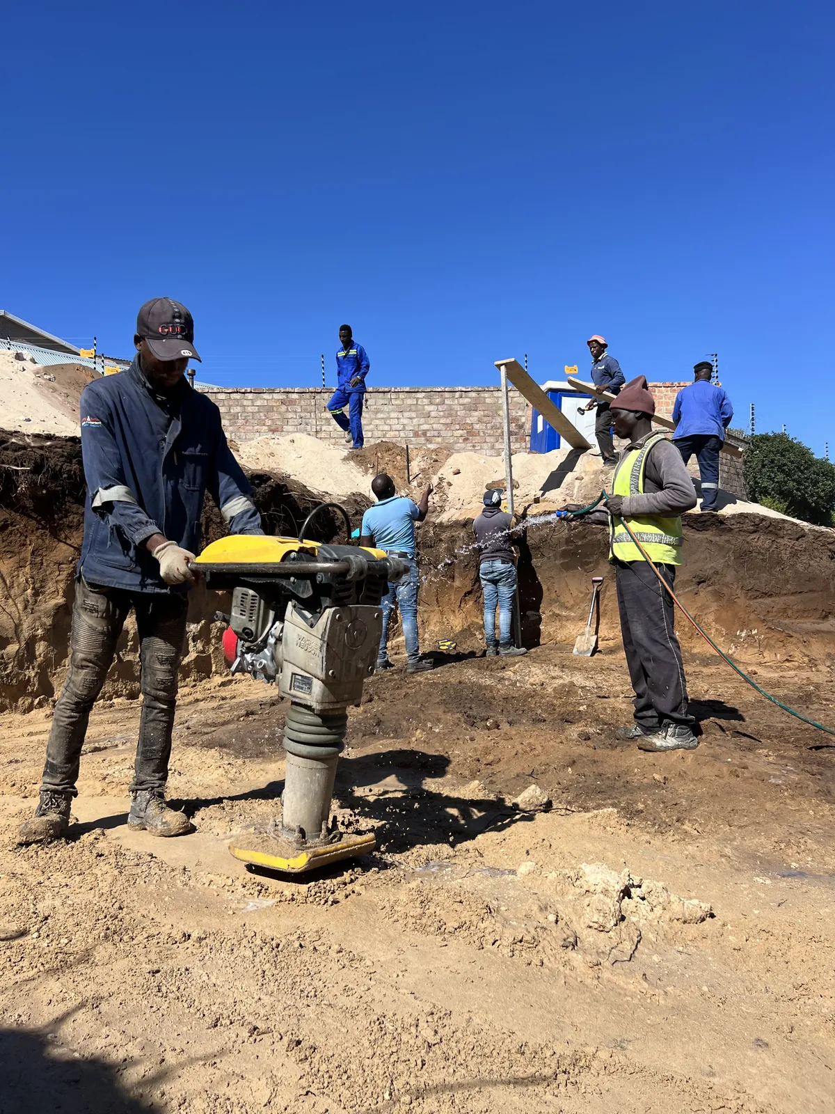 Compacting and wetting the ground in layers before the foundations