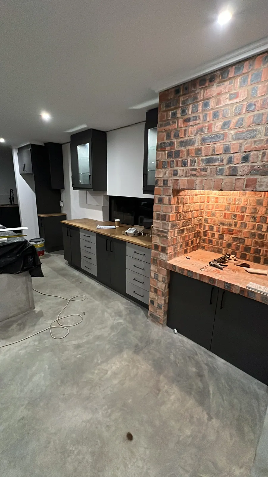 Kitchen cabinets and face-brick braai being fitted