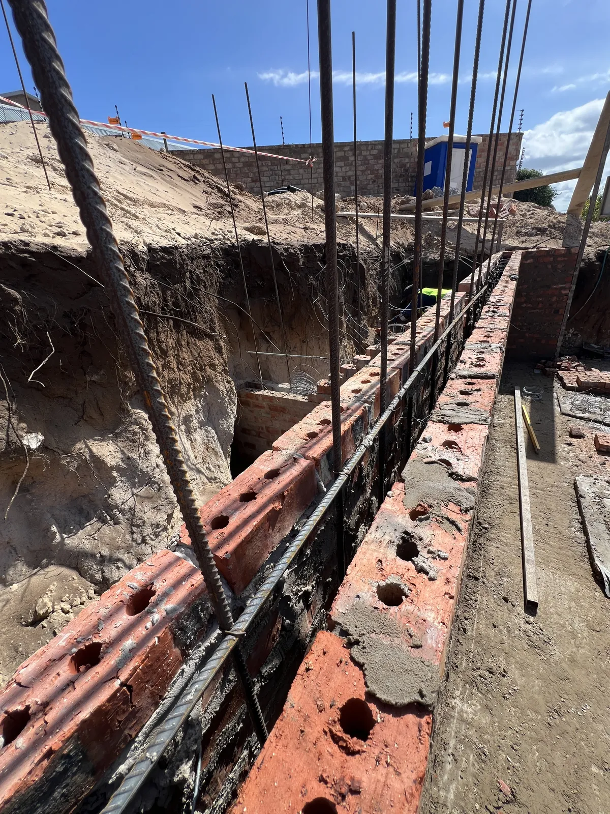 Reinforced brick retaining wall against the cut bank