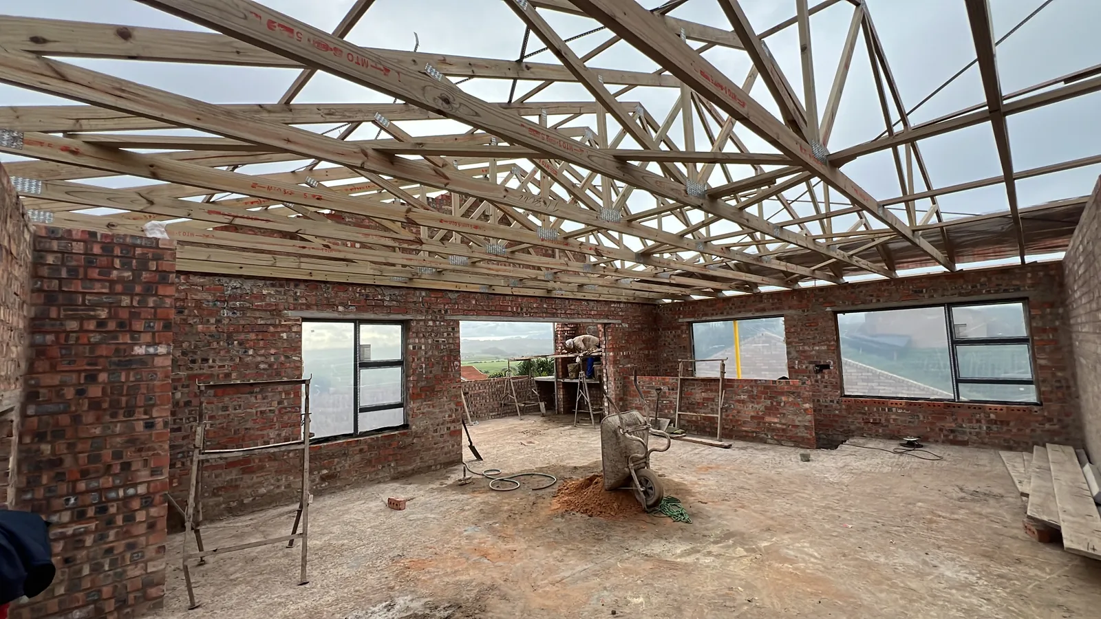 Roof trusses up over the open-plan living area, with views over the valley