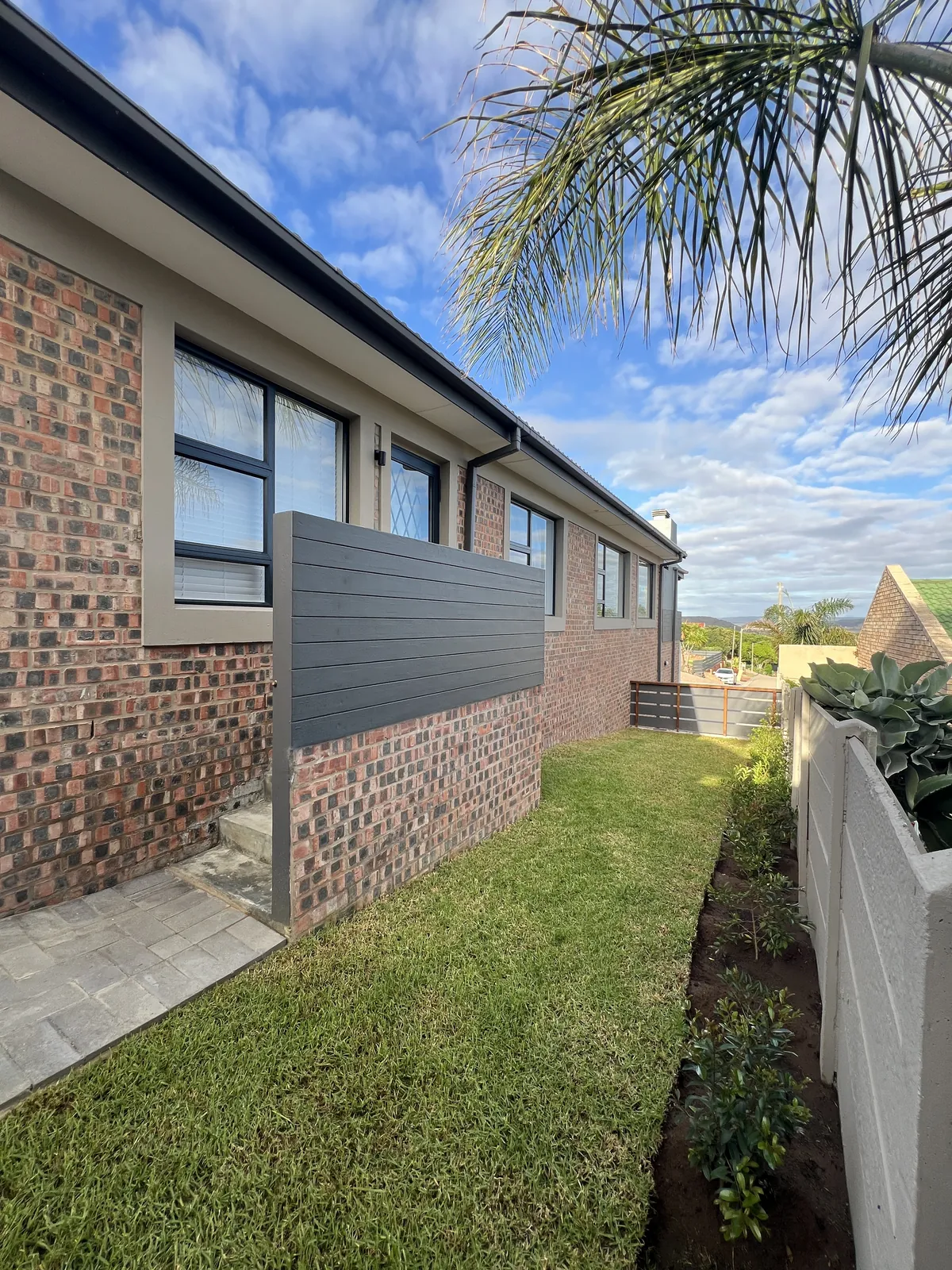 Side garden with face brick and grey grooved plaster