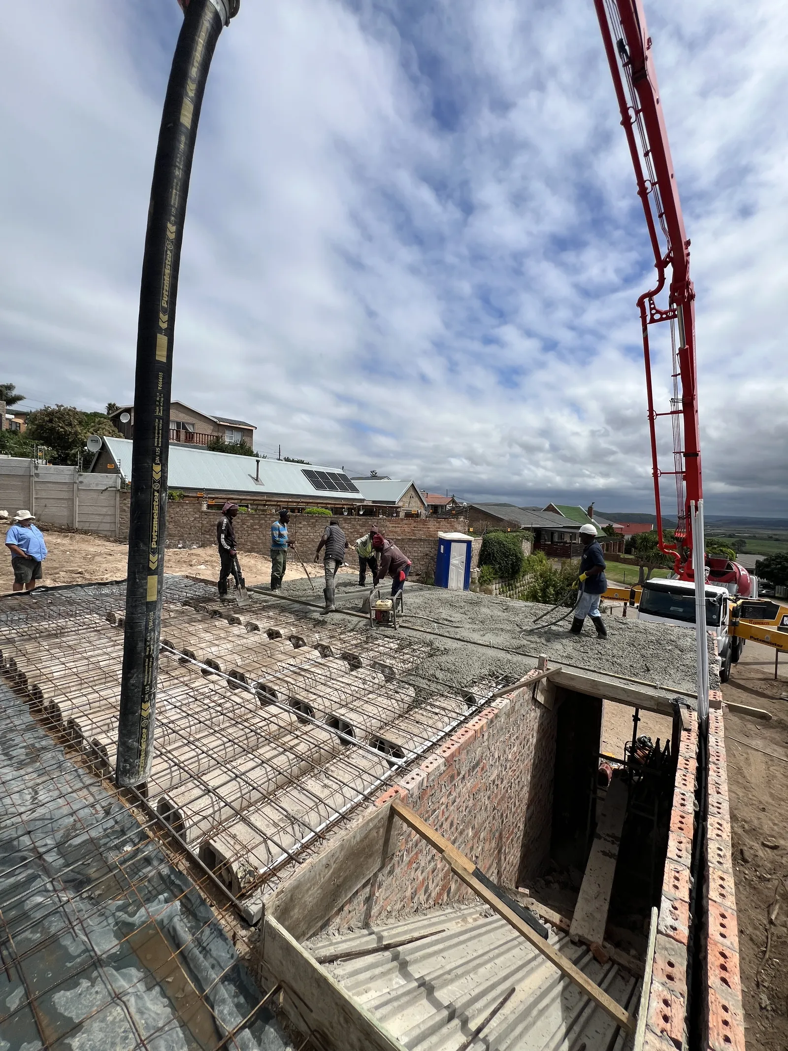 The team levelling the concrete as the pump pours the slab