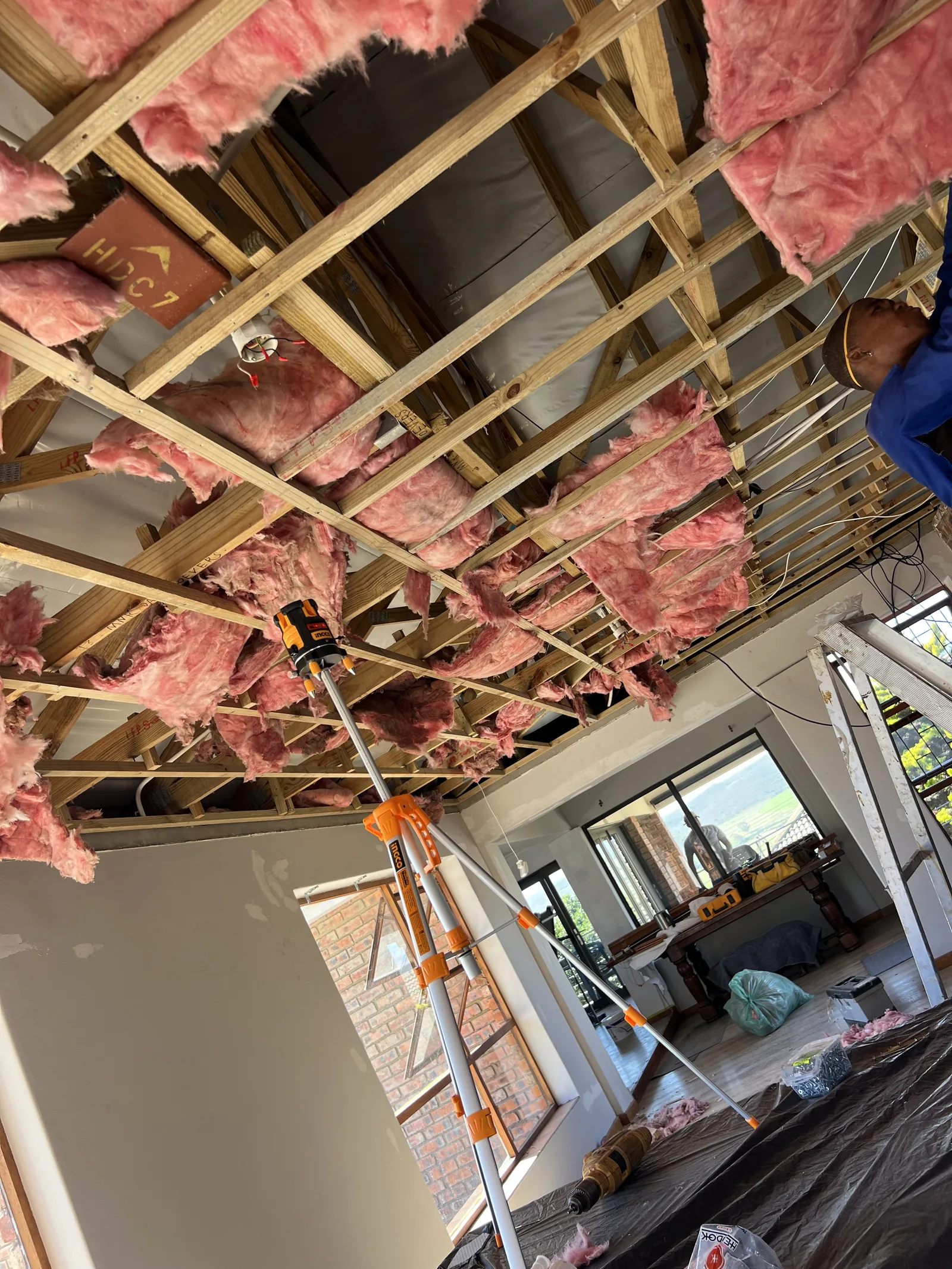 Old ceilings removed across the upstairs living area, with a laser level set up for the new ceiling