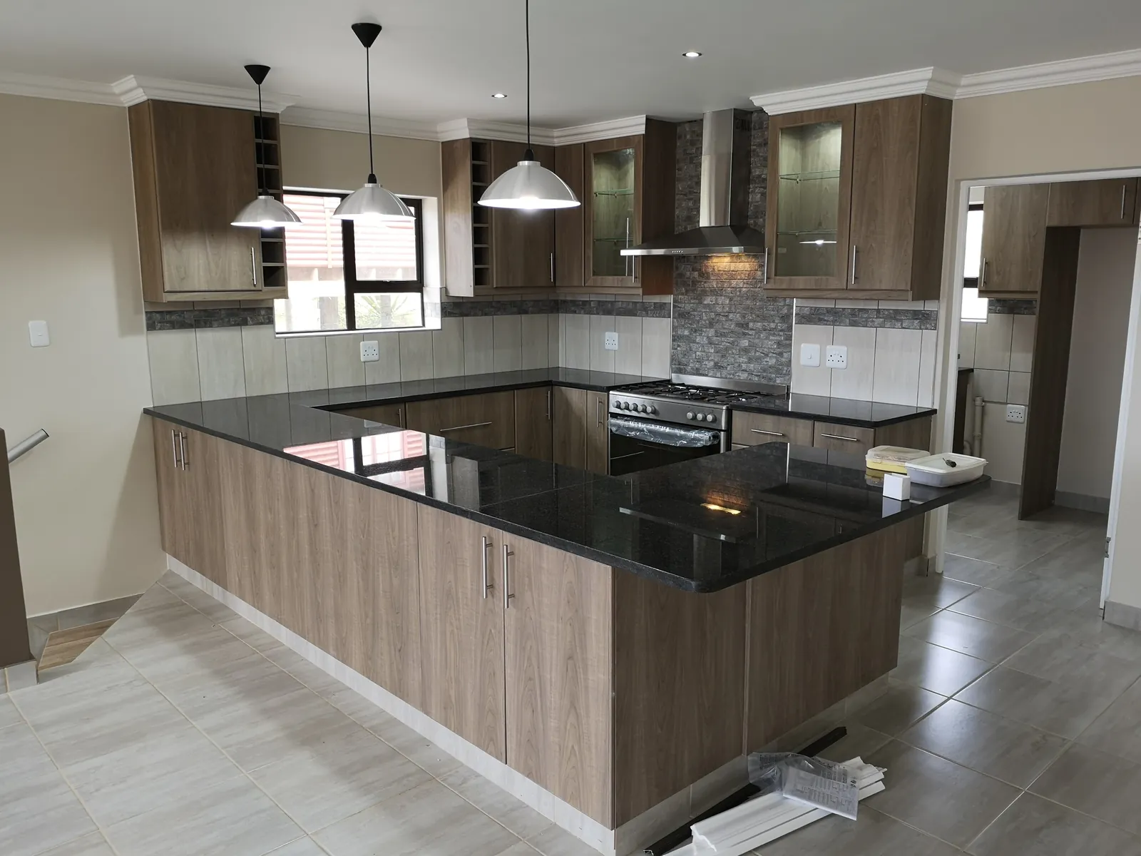 Upstairs kitchen with granite tops, pendant lights and a breakfast counter