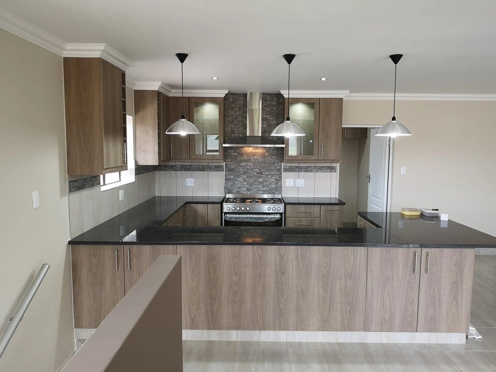 Kitchen with glass-front cabinets, gas stove and extractor