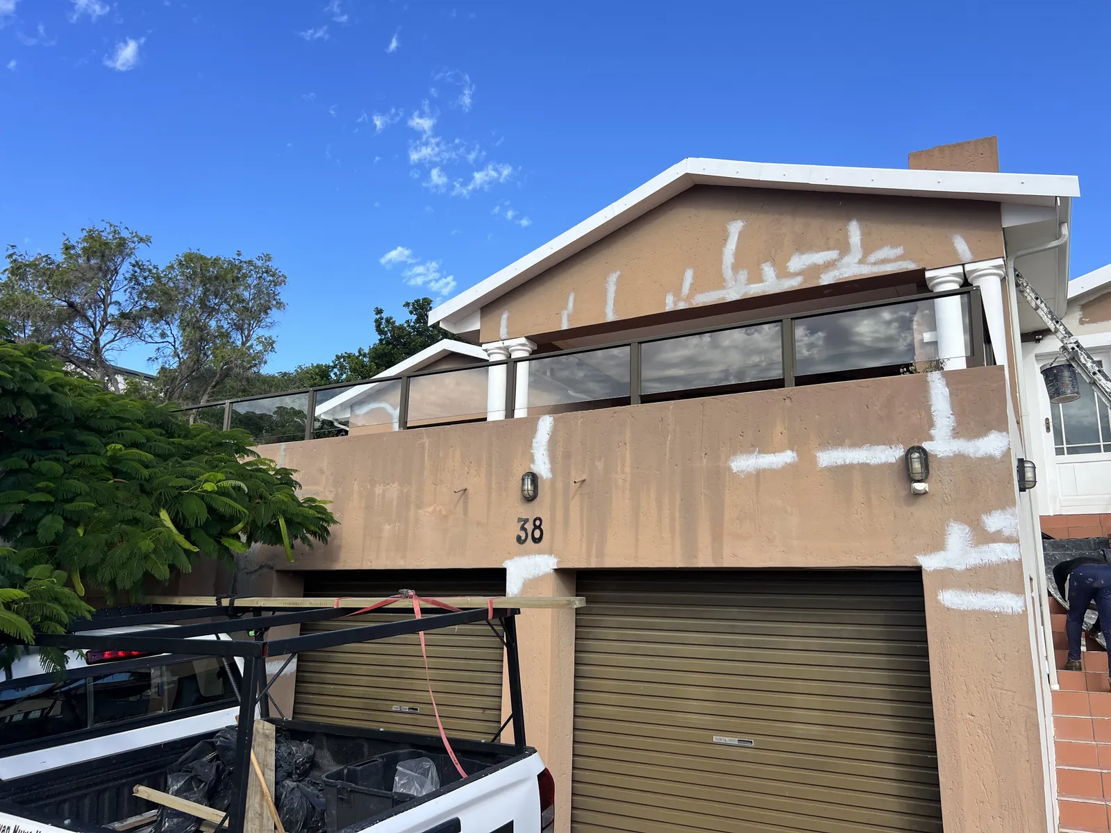 Crack and water-damage repairs spot-primed on the front of the house