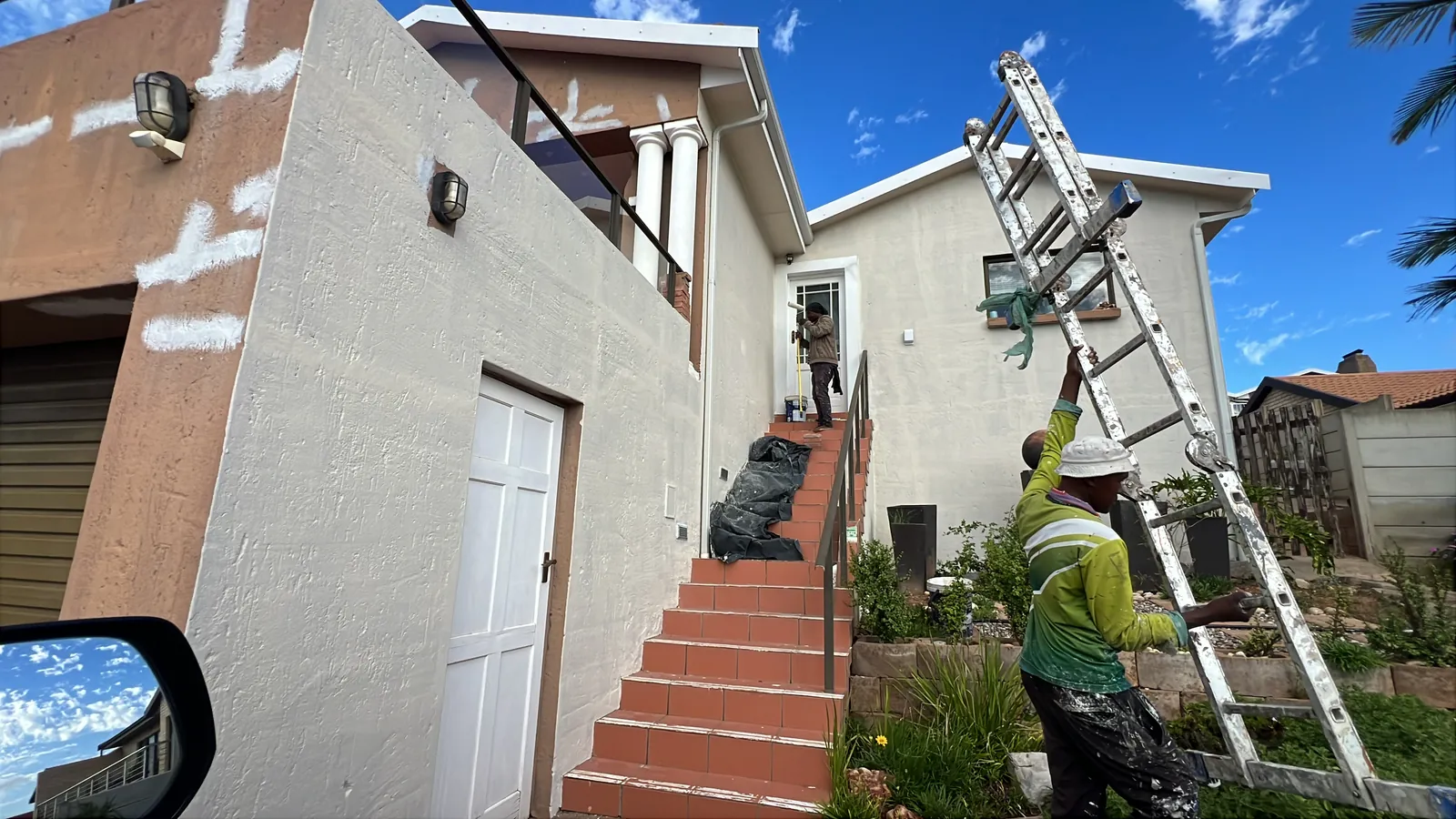 Painting along the entrance stairs while the front is primed