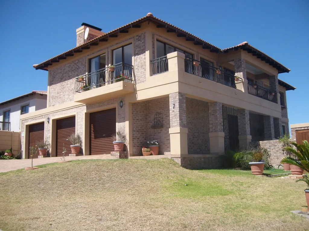 House Wildevy: double-storey face-brick home with triple garage and wrought-iron balconies