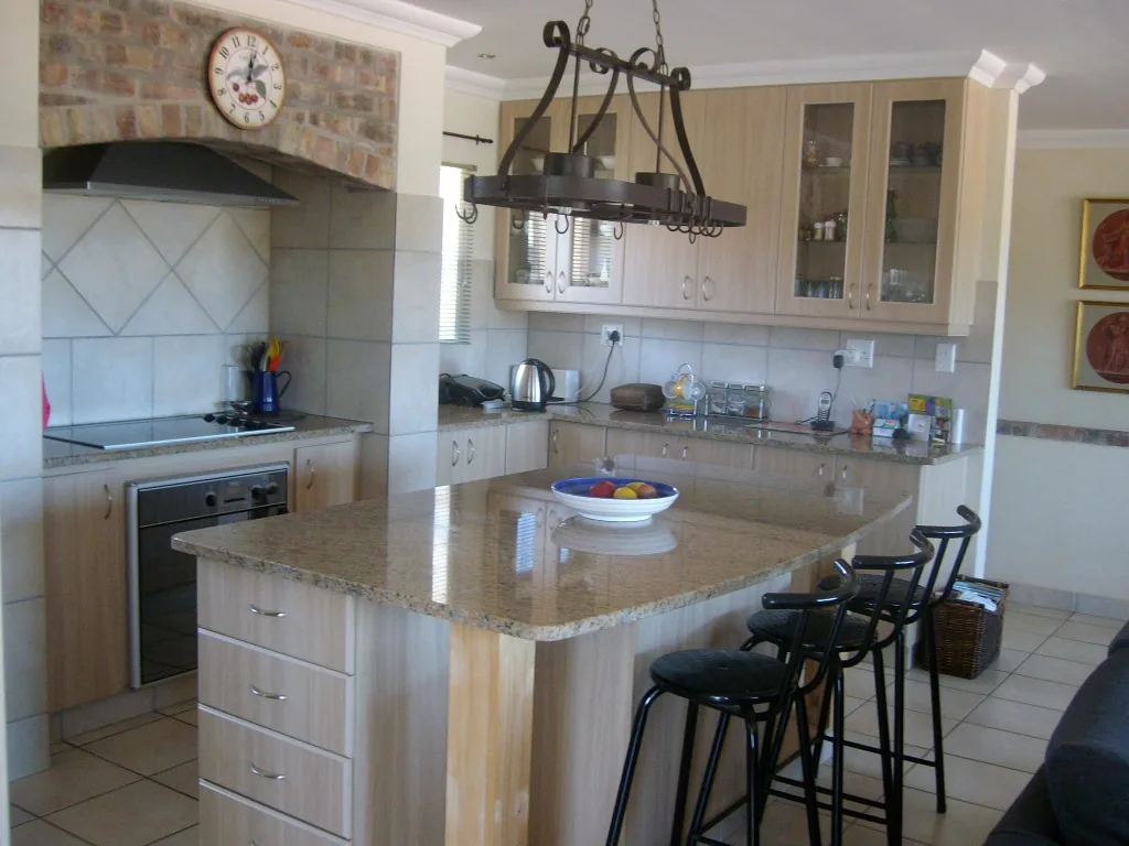 Kitchen with granite island and cooking alcove with face-brick surround