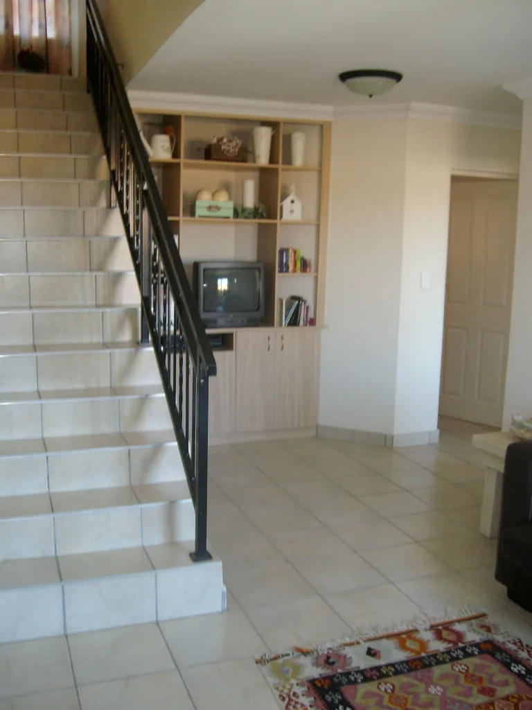 Tiled staircase with steel balustrade and built-in shelving