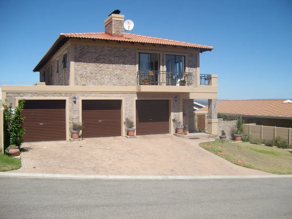 House Wildevy from the street, with triple garage and paved driveway